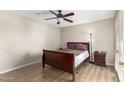 Bedroom with wood-look flooring, ceiling fan, and a dark wood sleigh bed and nightstand at 1217 N Miller Rd # 32, Scottsdale, AZ 85257