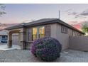Side view of a well-maintained single-story home with manicured landscaping at 14556 W Shaw Butte Dr, Surprise, AZ 85379