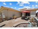 A cozy outdoor space features a stone patio with comfortable seating under a red umbrella at 1788 W Dion Dr, Anthem, AZ 85086