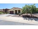 Charming single-story home featuring a well-maintained front yard, desert landscaping, and a cozy front porch at 17947 W Jojoba Rd, Goodyear, AZ 85338
