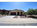 Well-manicured single-story home with desert landscaping, neutral color palette, and attached two-car garage at 17947 W Jojoba Rd, Goodyear, AZ 85338