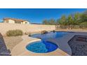 Stunning backyard pool and spa with rock waterfall feature, surrounded by desert landscaping at 18414 W La Mirada Dr, Goodyear, AZ 85338