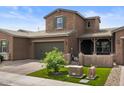 Charming two-story home showcasing a well-manicured lawn and a covered porch area at 1906 N 140Th Dr, Goodyear, AZ 85395