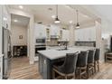 Modern kitchen featuring white cabinets, stainless steel appliances, and a gray island with seating at 1906 N 140Th Dr, Goodyear, AZ 85395