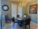 Bright dining room featuring a glass table, modern chairs, and natural light streaming through the window shutters at 20376 N Coronado Way, Surprise, AZ 85374
