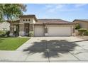 A single-story home with a neutral color palette, multi-car garage, and a tile roof at 2226 W Periwinkle Way, Chandler, AZ 85248