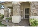 Inviting front porch featuring stone pillars, decorative plants, and a secure screen door entrance at 2226 W Periwinkle Way, Chandler, AZ 85248
