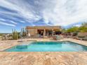 Backyard pool with tiled deck and desert landscaping, perfect for outdoor entertaining at 29619 N 142Nd Pl, Scottsdale, AZ 85262