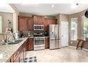 Well-appointed kitchen with stainless steel appliances, granite countertops, and rich wood cabinets for a modern gourmet experience at 3241 E Hampton Ln, Gilbert, AZ 85295