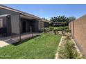 A lush back yard with healthy green grass and decorative plants and a partial covered patio at 3284 E Sandy Way, Gilbert, AZ 85297