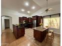 Well-lit kitchen with dark wood cabinets, a kitchen island, and stainless-steel appliances at 3284 E Sandy Way, Gilbert, AZ 85297