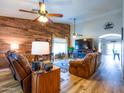 Cozy living room showcasing a wood accent wall and comfortable leather seating, perfect for relaxation at 34942 N Camp Fire Cir, San Tan Valley, AZ 85144