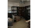 Cluttered storage room featuring a ceiling fan, assorted shelving units, and various stored items at 3556 E Helena Dr, Phoenix, AZ 85032
