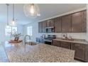 Kitchen island with granite countertop, pendant lighting, and stainless steel appliances at 4150 S Neutron --, Mesa, AZ 85212