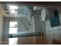 Full bathroom with shower-tub, white sink and toilet, and a plush turquoise rug at 4223 E Earll Dr, Phoenix, AZ 85018