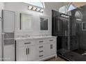 Updated bathroom with double sinks, marble countertops, and a glass-enclosed shower at 4321 E Rowel Rd, Phoenix, AZ 85050