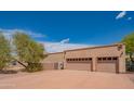 Spacious three-car garage exterior, complemented by desert landscaping and a wide driveway at 4706 E Rancho Caliente Dr, Cave Creek, AZ 85331