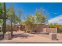 Charming single-story home featuring a desert-landscaped front yard with mature trees and native plants at 4706 E Rancho Caliente Dr, Cave Creek, AZ 85331