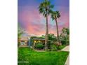 Serene backyard featuring a lush green lawn, mature trees, and a covered patio area for outdoor enjoyment at 512 W Roma Ave, Phoenix, AZ 85013