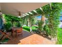 Relaxing covered patio with an outdoor dining set and vine-covered pergola for shaded comfort at 512 W Roma Ave, Phoenix, AZ 85013