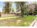 Inviting single-story home featuring a brick facade and a lush green lawn with mature trees at 523 W 14Th St, Tempe, AZ 85281