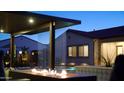 Backyard at night with fire pit, lit pool, and relaxing lounge seating; an outdoor oasis for entertaining at 5457 S Benton --, Mesa, AZ 85212