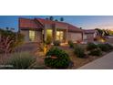 Charming single-story home with desert landscaping, lighting, and a terra cotta roof at dusk at 5831 W Saragosa St, Chandler, AZ 85226