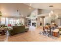 Bright living room with vaulted ceiling, neutral paint, fireplace, tile floors, and views of the backyard at 5831 W Saragosa St, Chandler, AZ 85226