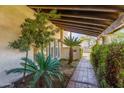 Inviting entryway featuring lush landscaping, a brick path, and a covered porch with exposed wood beams at 6011 N 2Nd St, Phoenix, AZ 85012