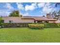 Charming single-story home featuring desert landscaping and mature shrubbery, set against a bright sky at 6011 N 2Nd St, Phoenix, AZ 85012