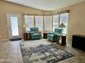 Comfortable living room featuring tile flooring, two plush chairs, and a wall of windows at 650 N Hawes Rd # 2827, Mesa, AZ 85207