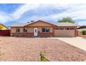 Inviting single-story home with a gravel yard and a well-lit entrance, complemented by an attached two-car garage at 655 E Hondo Ave, Apache Junction, AZ 85119