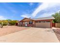 Well-maintained single-story house with a spacious driveway leading to an attached garage, complemented by a gravel yard at 655 E Hondo Ave, Apache Junction, AZ 85119