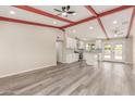Bright open-concept living room and kitchen with exposed beam and wood laminate flooring at 655 E Hondo Ave, Apache Junction, AZ 85119