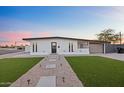 Charming home with gravel landscaping, a walkway, a minimalist lawn and a black trimmed flat roof at 7802 E Kimsey Ln, Scottsdale, AZ 85257