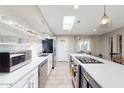 Bright, modern kitchen with a skylight, white cabinets, and stainless steel appliances at 7802 E Kimsey Ln, Scottsdale, AZ 85257