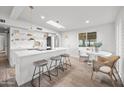 Bright, modern kitchen with white cabinets, a skylight, a breakfast bar with seating and wood floors at 7802 E Kimsey Ln, Scottsdale, AZ 85257