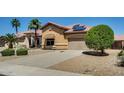 Well-maintained property featuring desert landscaping, mature trees, and solar panels at 11664 W Eagle Ct, Surprise, AZ 85378