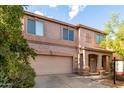 Inviting two-story home showcasing desert landscaping, a two-car garage, and covered front porch at 1222 E Canyon Trl, San Tan Valley, AZ 85143
