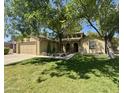 Charming home featuring a well-manicured lawn, mature trees, and a welcoming, arched front entrance at 1308 E Rosemonte Dr, Phoenix, AZ 85024
