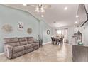 Open-concept living room with tile floors, ceiling fan, and ample natural light at 18555 N 114Th Ave, Surprise, AZ 85378