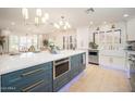 Spacious kitchen island with bar seating, built-in microwave, undermount lighting and stainless steel appliances at 18823 N 97Th Ln, Peoria, AZ 85382