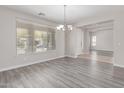 Formal dining room with wood flooring, a chandelier, and natural light from a large window with blinds at 18868 E Canary Way, Queen Creek, AZ 85142