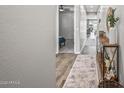 Bright hallway featuring wood-look floors, neutral paint, and modern decor at 22491 E Mewes Rd, Queen Creek, AZ 85142
