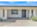 A welcoming front porch with decorative columns and a stylish, dark-colored front door at 2424 E Fairfield St, Mesa, AZ 85213