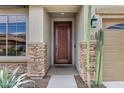 Stylish front entrance featuring a solid wood door, stone accents, and desert landscaping at 3033 W Redwood Ln, Phoenix, AZ 85045