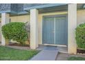 Inviting front entrance with a blue double door, supported columns, and vibrant green landscaping at 3222 W Royal Palm Rd, Phoenix, AZ 85051