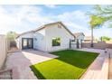 A landscaped backyard features an artificial turf area, brick patio and block wall for privacy at 33105 N Double Bar Rd, San Tan Valley, AZ 85144