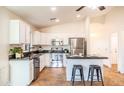 A bright kitchen features stainless steel appliances, white cabinets, and a breakfast bar with seating at 33105 N Double Bar Rd, San Tan Valley, AZ 85144