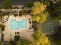 Aerial view shows pool, patio seating, basketball court surrounded by trees at 4313 E Jasper Dr, Gilbert, AZ 85296